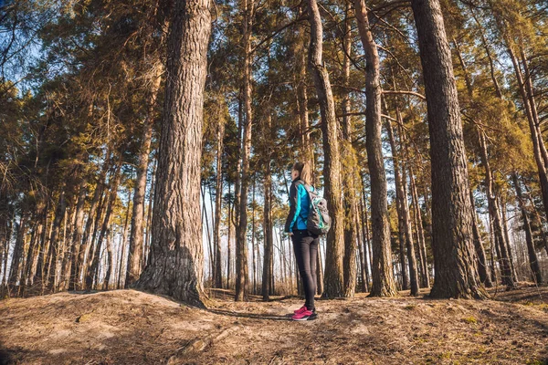 若い女性が春の松の木を歩いていて. — ストック写真