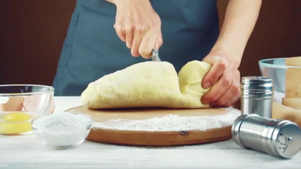 Женщина-повар разминает тесто на деревянном столе. — стоковое видео
