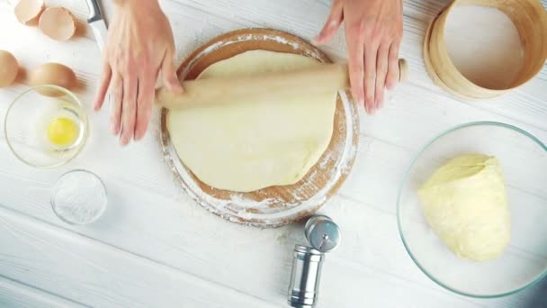Женщина-повар разминает тесто на деревянном столе. — стоковое видео