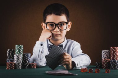 Küçük çocuk kumarhanede poker oynuyor..