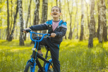 Ormanda bisikletle gezen mutlu çocuk..