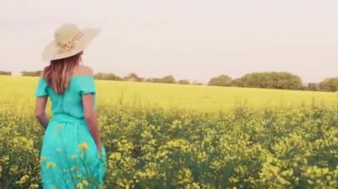 Tecavüz meydanında duran genç bir kadın ve arka planda güneş doğuyor.