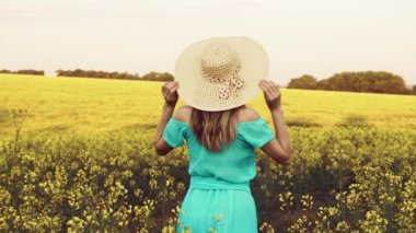 Tecavüz meydanında duran genç bir kadın ve arka planda güneş doğuyor.