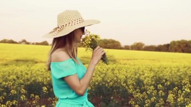 Tecavüz meydanında duran genç bir kadın ve arka planda güneş doğuyor.