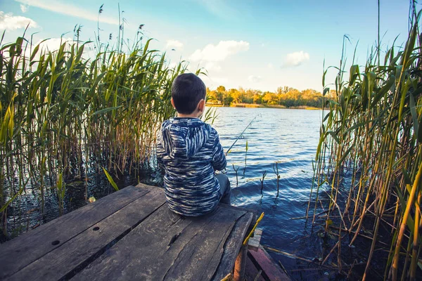Roztomilý chlapec chytá ryby na jezeře. — Stock fotografie