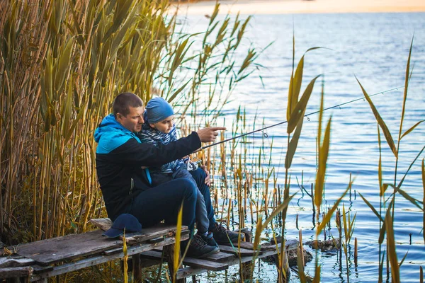 Roztomilý chlapec s tátou chytá ryby na letním jezeře. — Stock fotografie