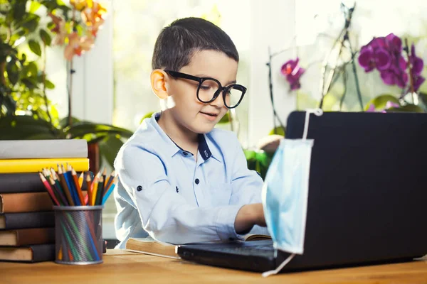 A srác laptopot használ a házi feladatához, a gyerek laptopot használ, hogy információt keressen az interneten — Stock Fotó