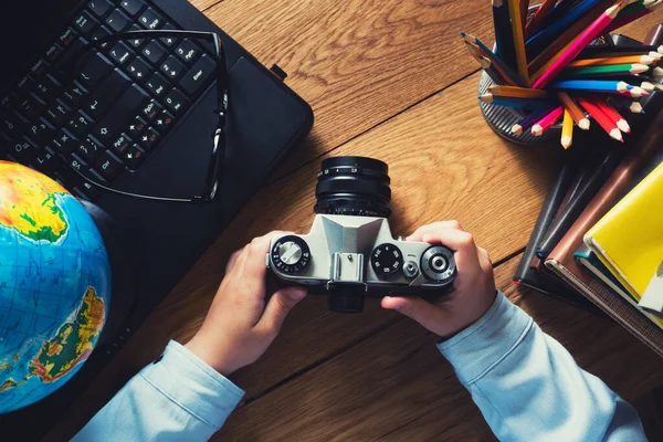 Desktop malého dětského fotografa. pohled shora. Fotoaparát a notebook na dřevěném stole — Stock fotografie