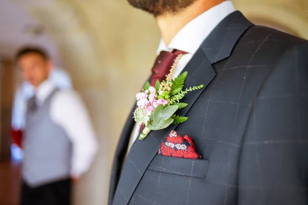 Деталь цветочного оформления на пиджаке жениха на свадьбе — стоковое фото