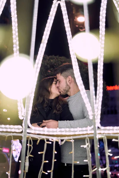 Jovem casal desfrutando de luzes de Natal — Fotografia de Stock