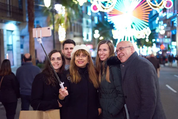 Vigo, Galiçya, İspanya 'daki Noel ışıklarında selfie çeken bir grup insan.