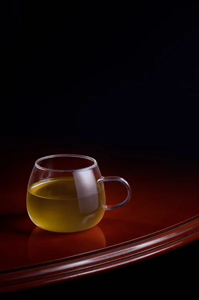 Egy Csésze Sárga Infúzió Egy Fényűző Asztalon Fekete Háttérrel — Stock Fotó