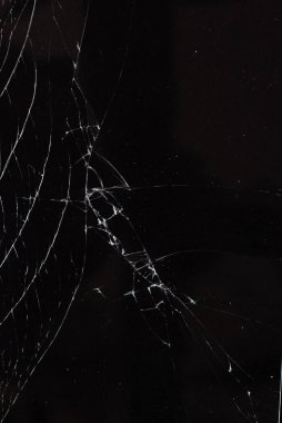 Siyah arka planda kırık cam var.