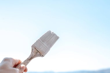 Gökyüzüne beyaz boya ile boya fırçası