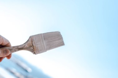 Gökyüzüne karşı beyaz boya ile boya fırçası