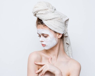 Duştan sonra kafasında havlu ve yüzünde kremayla güzel bir kadın..