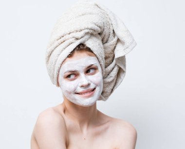 Duştan sonra kafasında havlu ve yüzünde kremayla güzel bir kadın..
