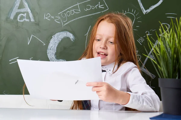 Escola de meninas, menina no quadro negro, menina com desenhos de papel — Fotografia de Stock