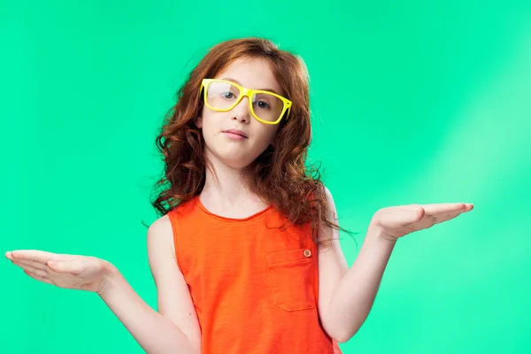 A kezét a zöld háttér, sárga szemüveges lány — Stock Fotó