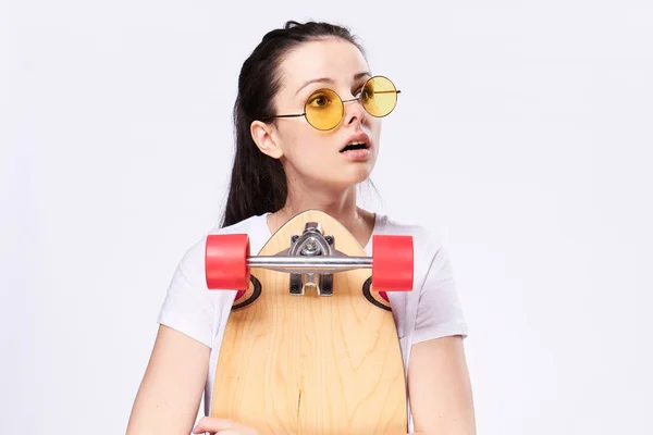 Una mujer con un monopatín en sus manos. Mujer en el estudio con monopatín —  Fotos de Stock