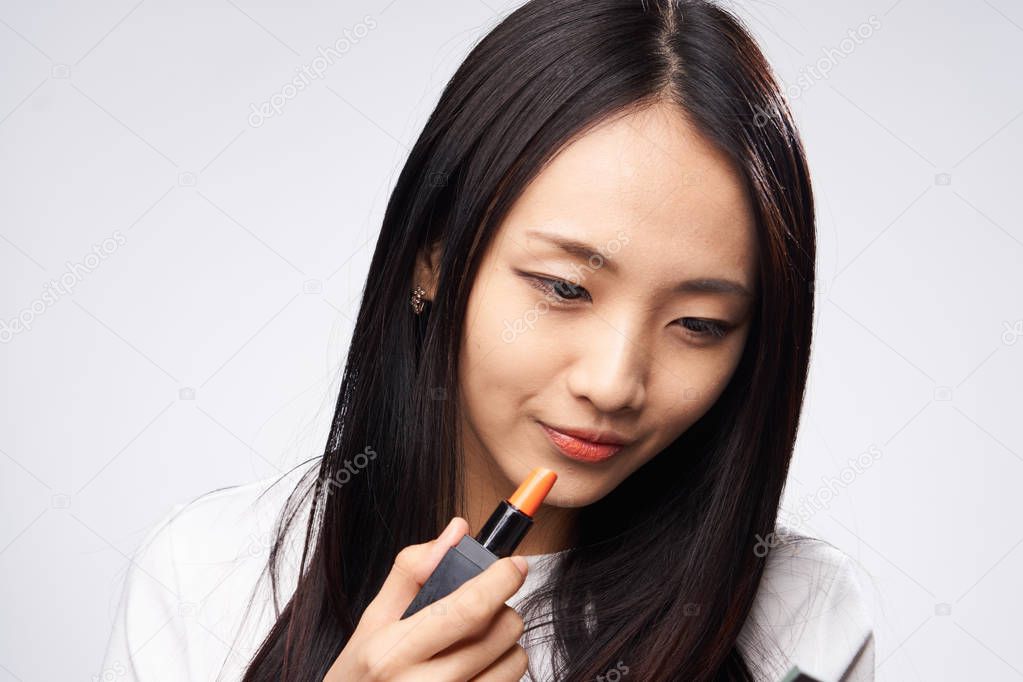 Woman asian paints makeup on face skin, woman enjoys makeup