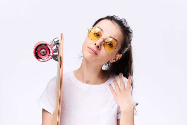 Eine Frau mit einem Skateboard in der Hand. Frau im Studio mit Skateboard — Stockfoto