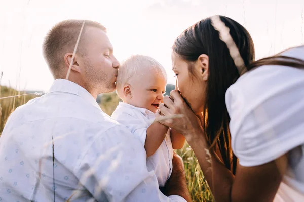 Parents embrasser bébé à l'extérieur — Photo