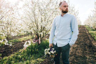 Genç çift çiçek açan bahçede yürüyüş