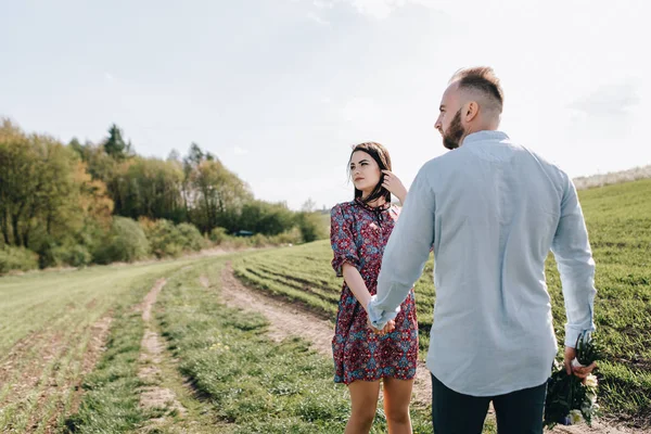 Ungt par promenader genom fältet — Stockfoto