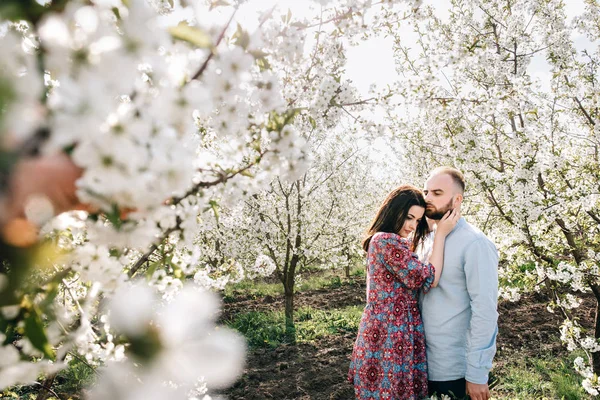 Ungt par promenader i den blommande trädgården — Stockfoto