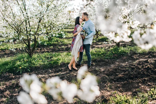 Jovem casal andando no jardim florido — Fotografia de Stock