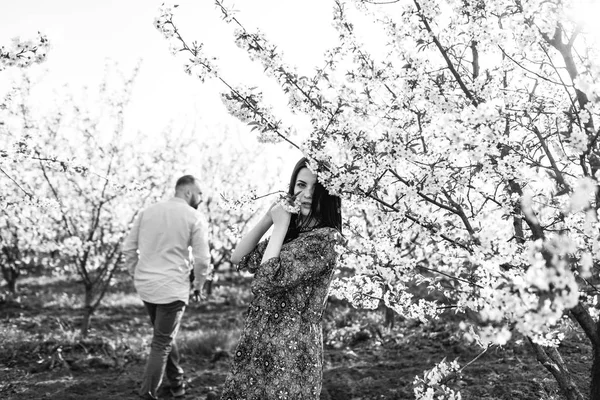 Jovem casal andando no jardim florido — Fotografia de Stock