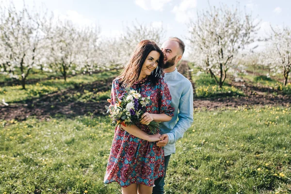 Giovane coppia a piedi nel giardino fiorito — Foto Stock
