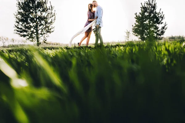 Giovane coppia a piedi attraverso il campo — Foto Stock