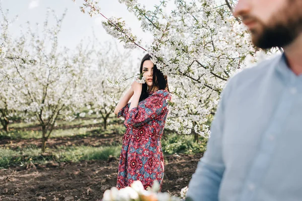 Junges Paar spaziert im blühenden Garten — Stockfoto