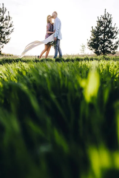 Ungt par promenader genom fältet — Stockfoto