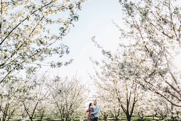 Giovane coppia a piedi nel giardino fiorito — Foto Stock