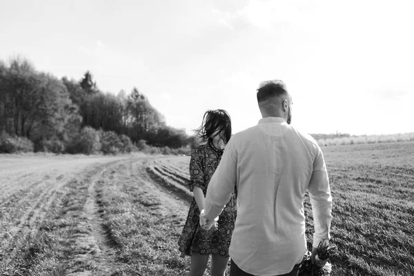 Jovem casal caminhando pelo campo — Fotografia de Stock