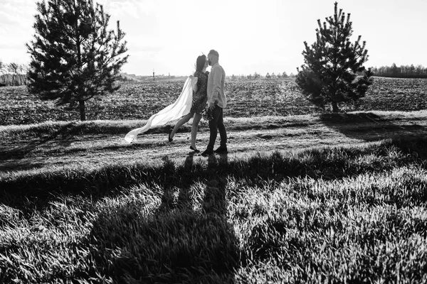 Jovem casal caminhando pelo campo — Fotografia de Stock