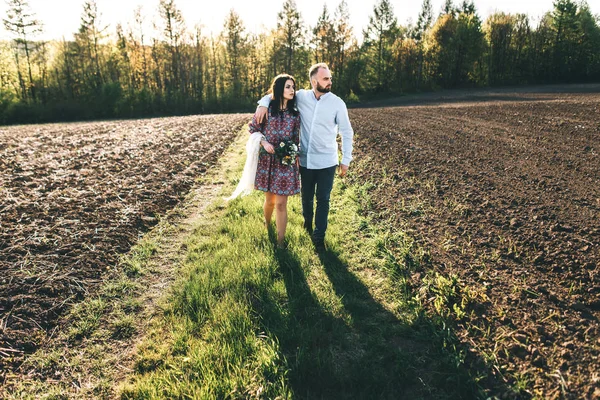 Jovem casal caminhando pelo campo — Fotografia de Stock