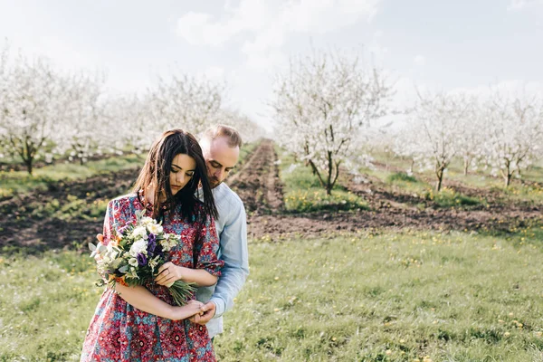 Jovem casal andando no jardim florido — Fotografia de Stock