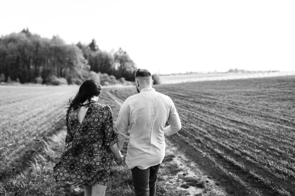 Jovem casal caminhando pelo campo — Fotografia de Stock