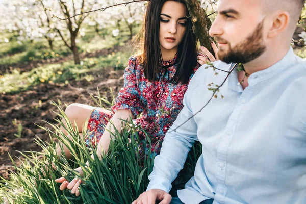 Young couple in the blooming garden — Stock Photo, Image