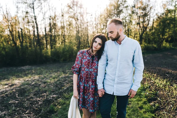 Young couple walking through the field — Stock Photo, Image