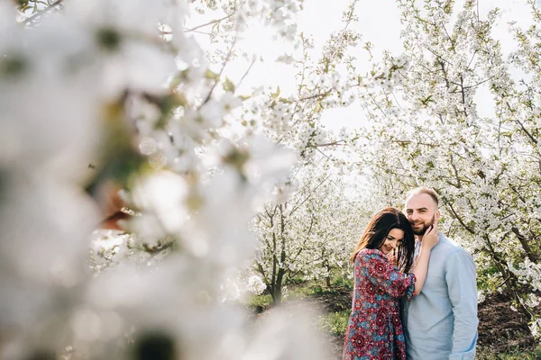 Jovem casal andando no jardim florido — Fotografia de Stock