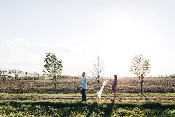 Junges Paar geht durch das Feld — Stockfoto