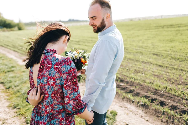 Jovem casal caminhando pelo campo — Fotografia de Stock