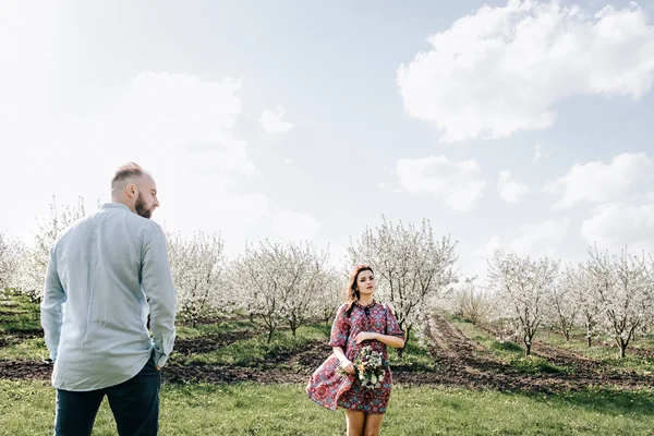 Jong koppel wandelen in de bloeiende tuin — Stockfoto