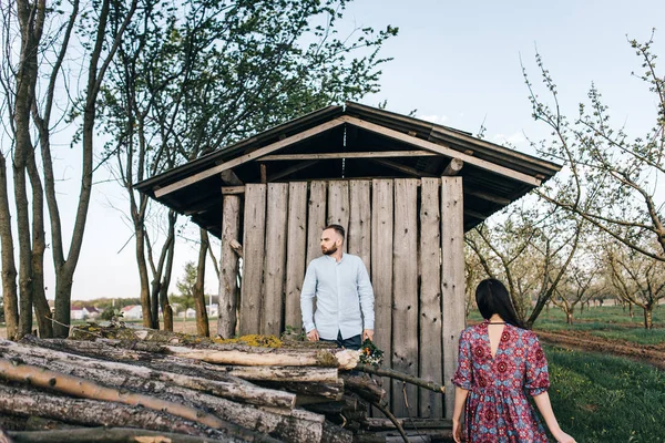 Jovem casal perto de uma velha casa de madeira — Fotografia de Stock