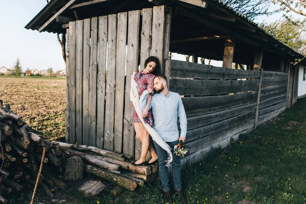 Jovem casal perto de uma velha casa de madeira — Fotografia de Stock
